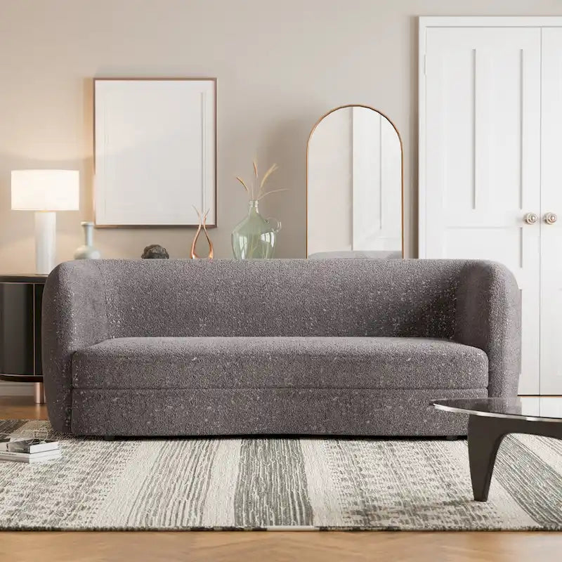 Canapé en bouclé moderne à accoudoirs courbés, assise en forme de rein et pieds ronds en bois
